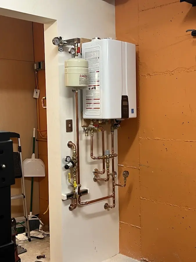 Plumbing technician inspecting water heater connections in Haverford